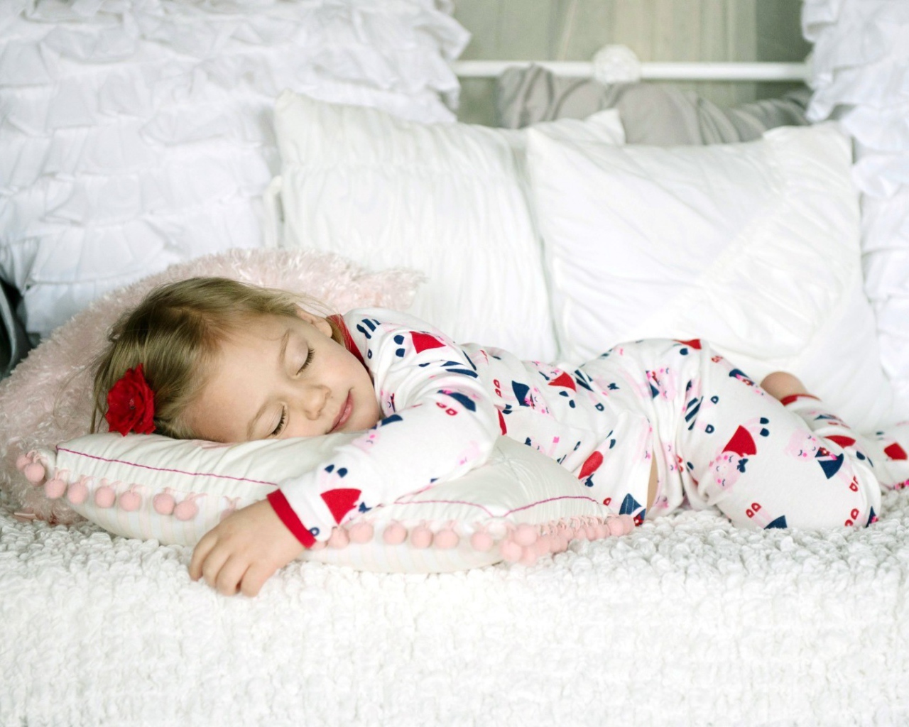 Девочка в пижаме спит на кровати