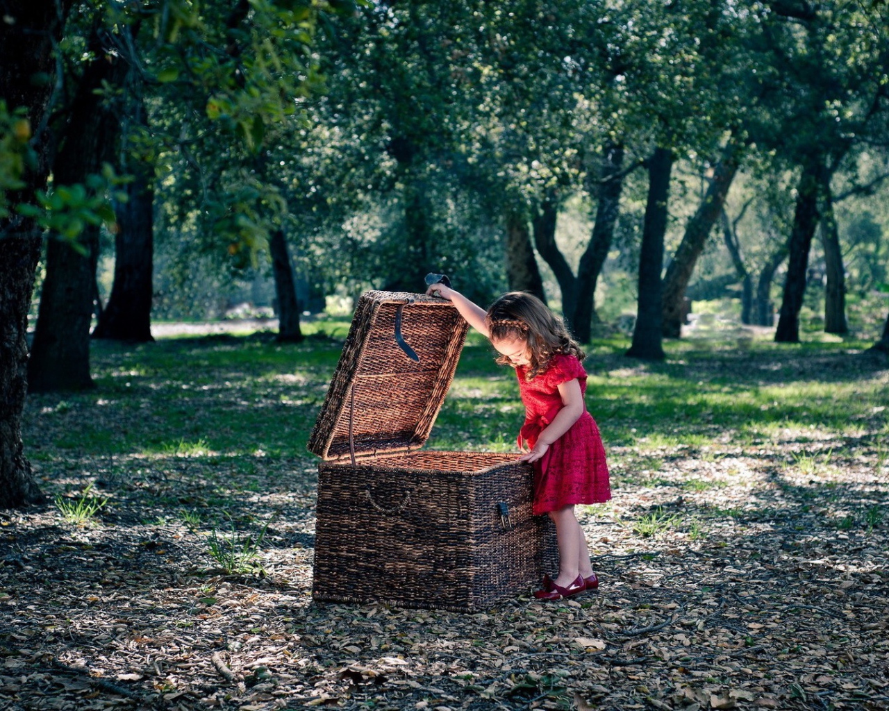 Девочка заглядывает в плетеную корзину