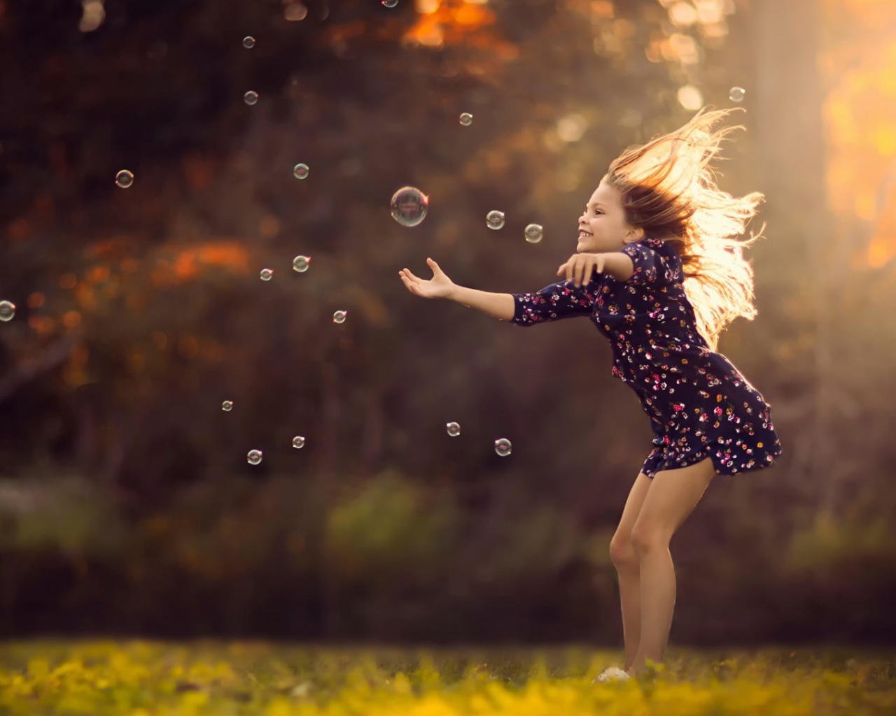 Девочка играет с мыльными пузырями