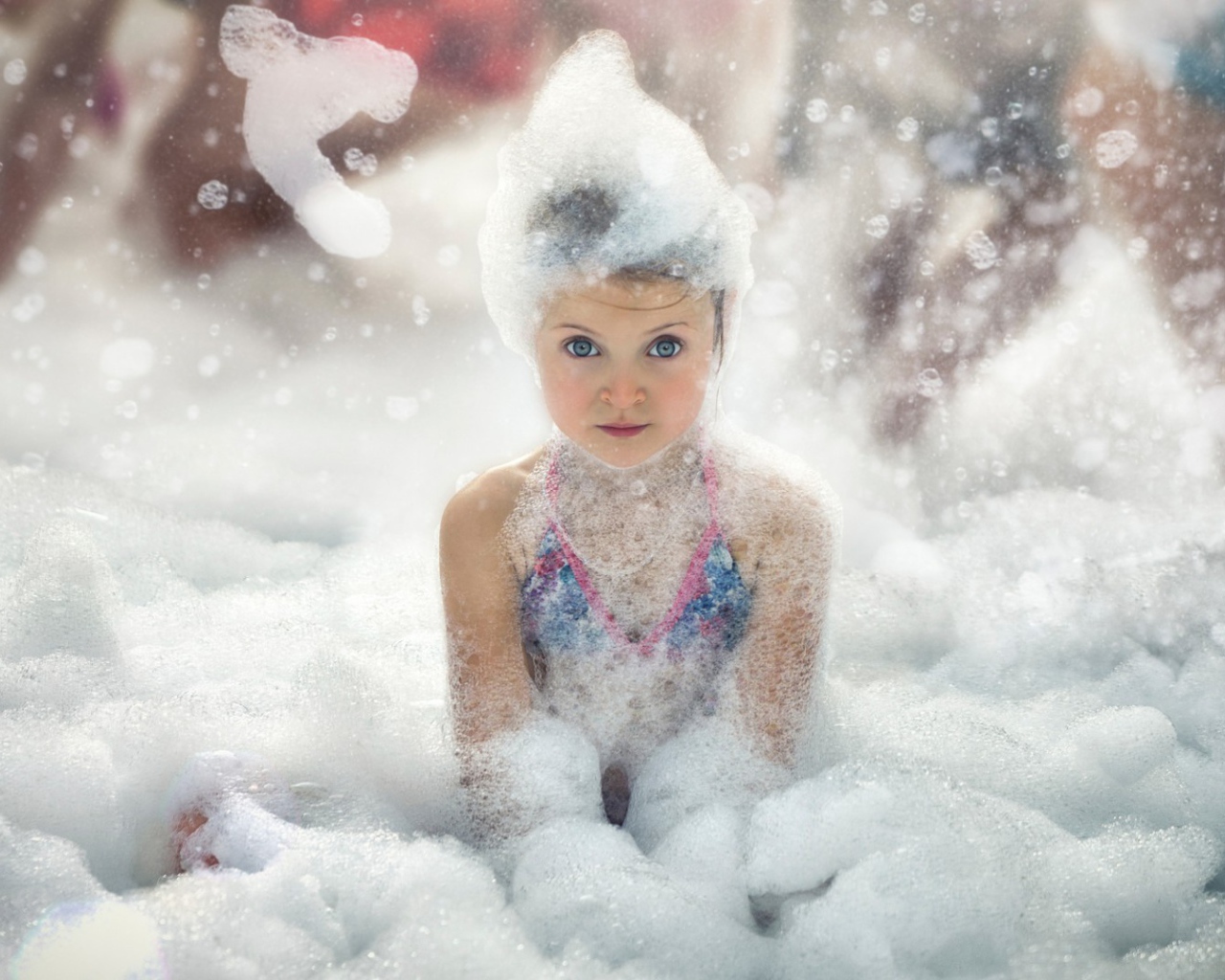 Девочка играет в пене