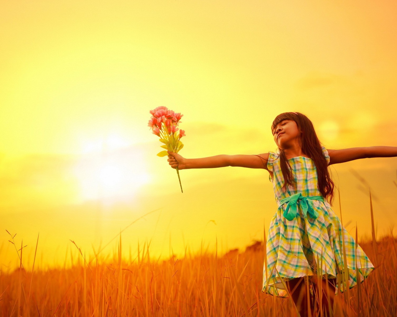 Девочка с букетом стоит в поле