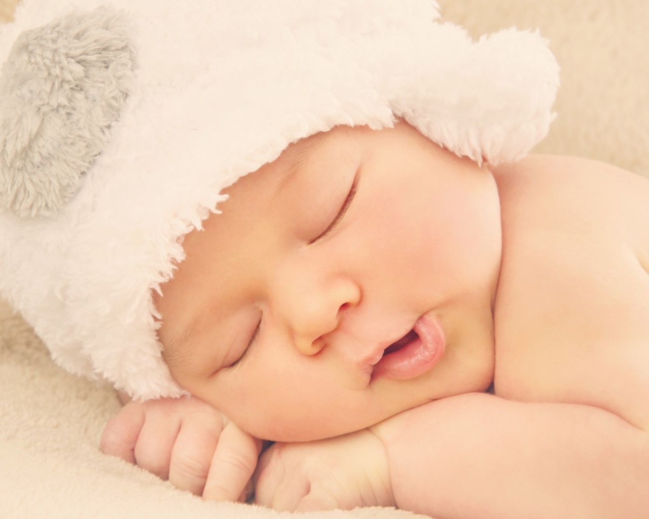 Спящий ребенок в белой шапке