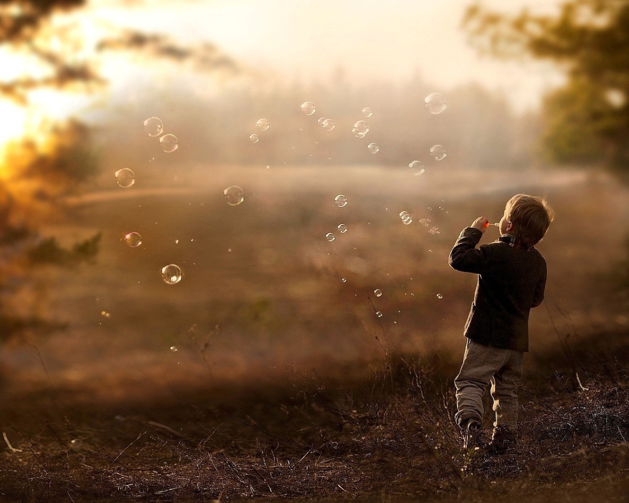 Мальчик запускает мыльные пузыри
