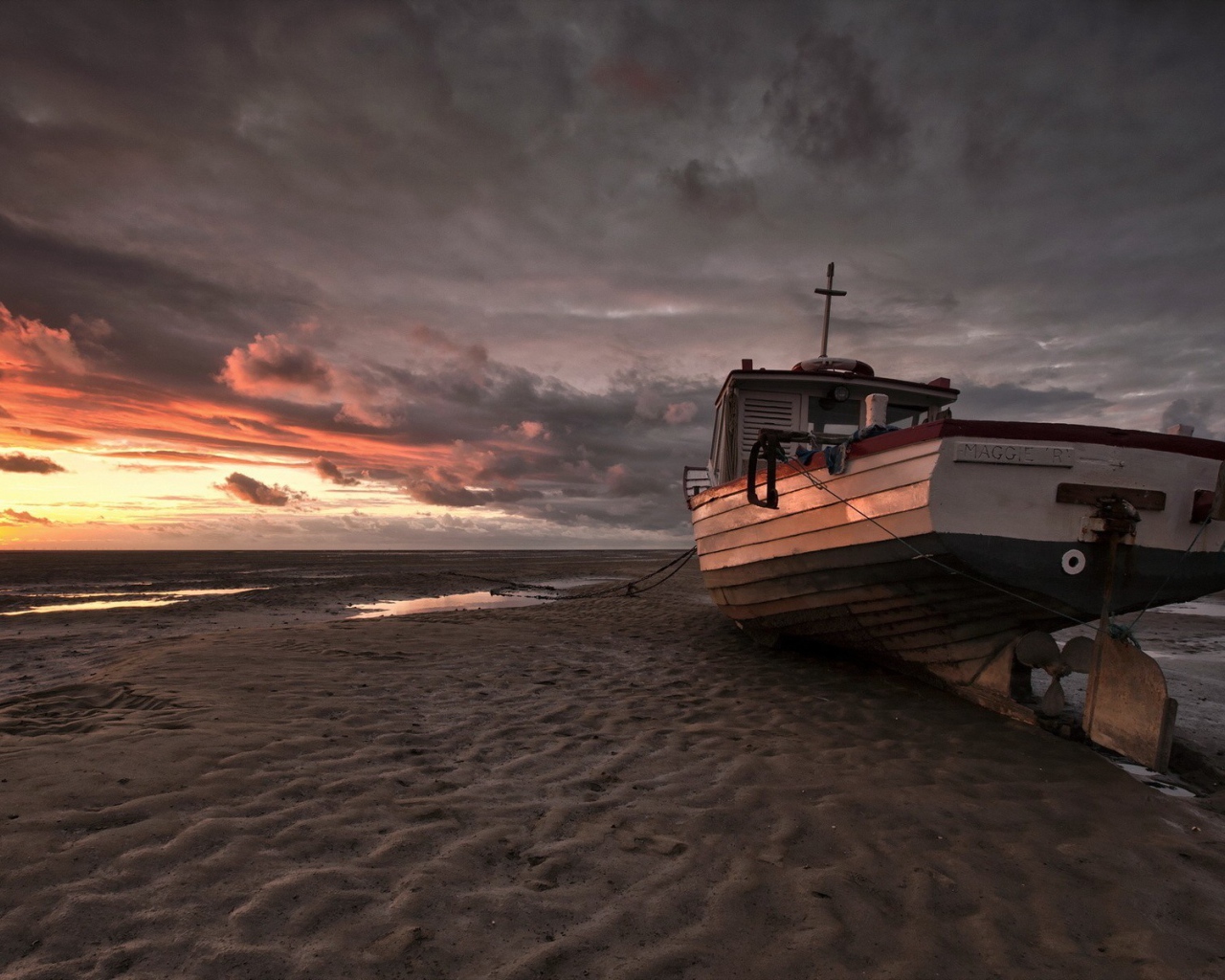 Лодка на песке пляжа во время отлива