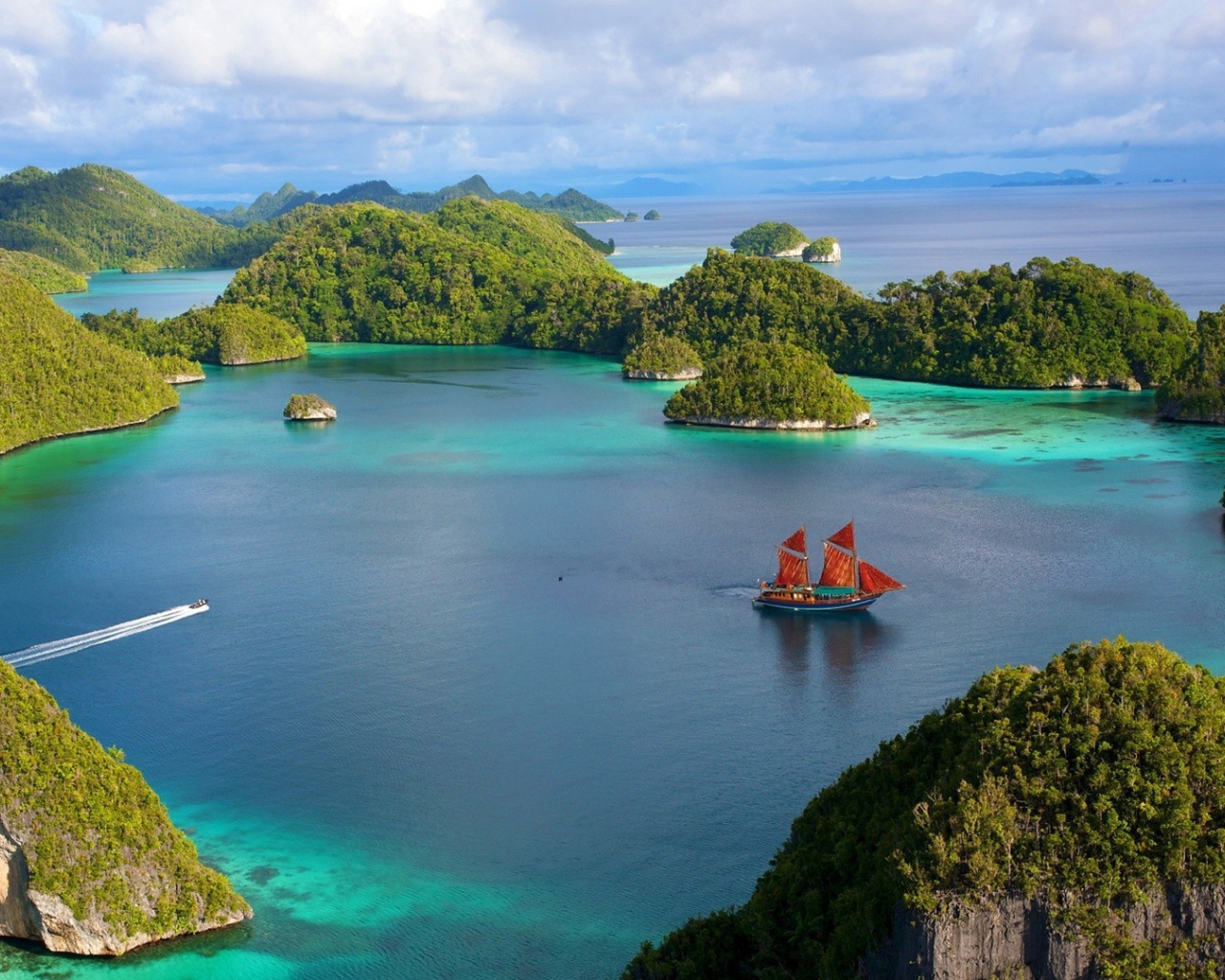 Корабль с красными парусами среди островов