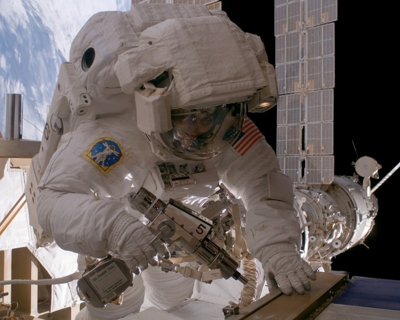 Космонавт на орбите выполняет ремонт