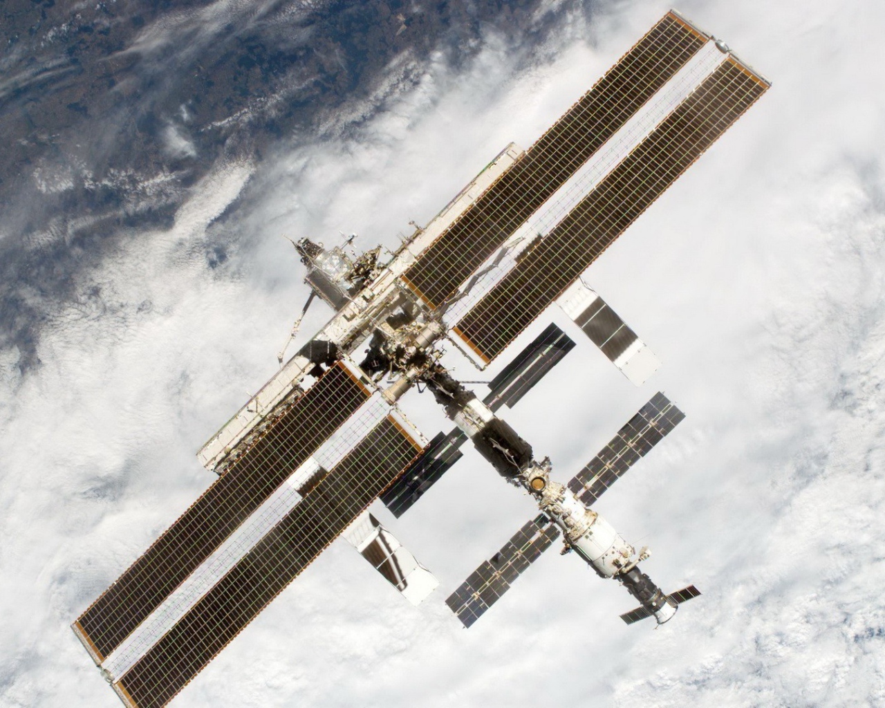 МКС пролетает над облаками на Земле