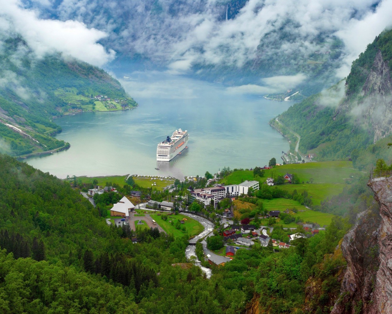 Круизный корабль у прибрежной деревушки в Норвегии