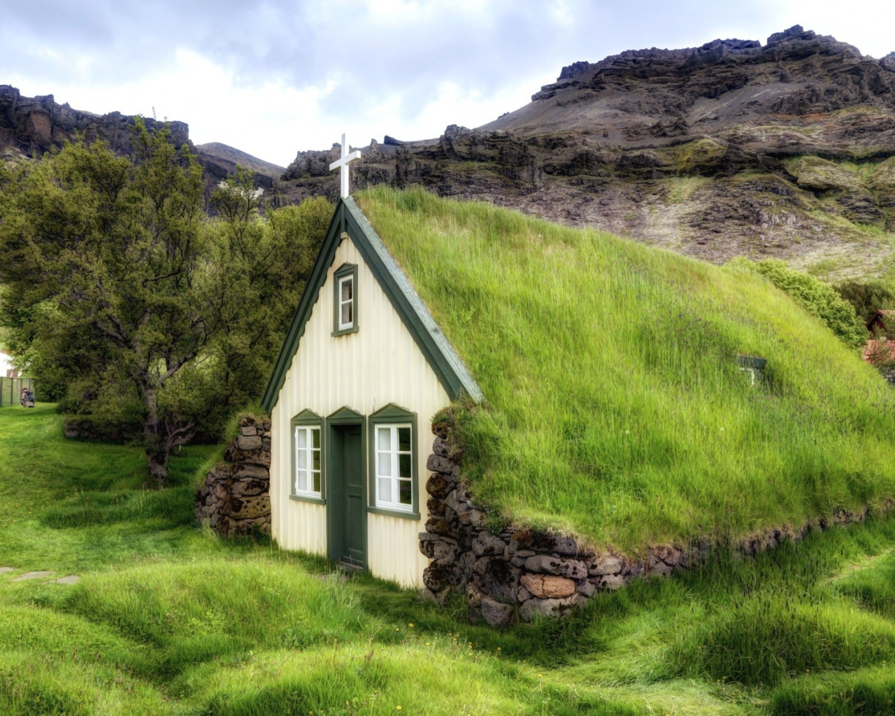 Поросшая травой крыша церкви в горной деревушке