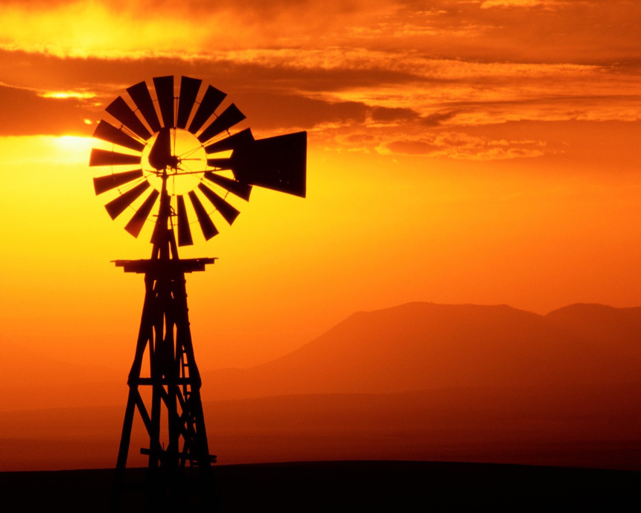 Ветряк флюгер на фоне заката, США