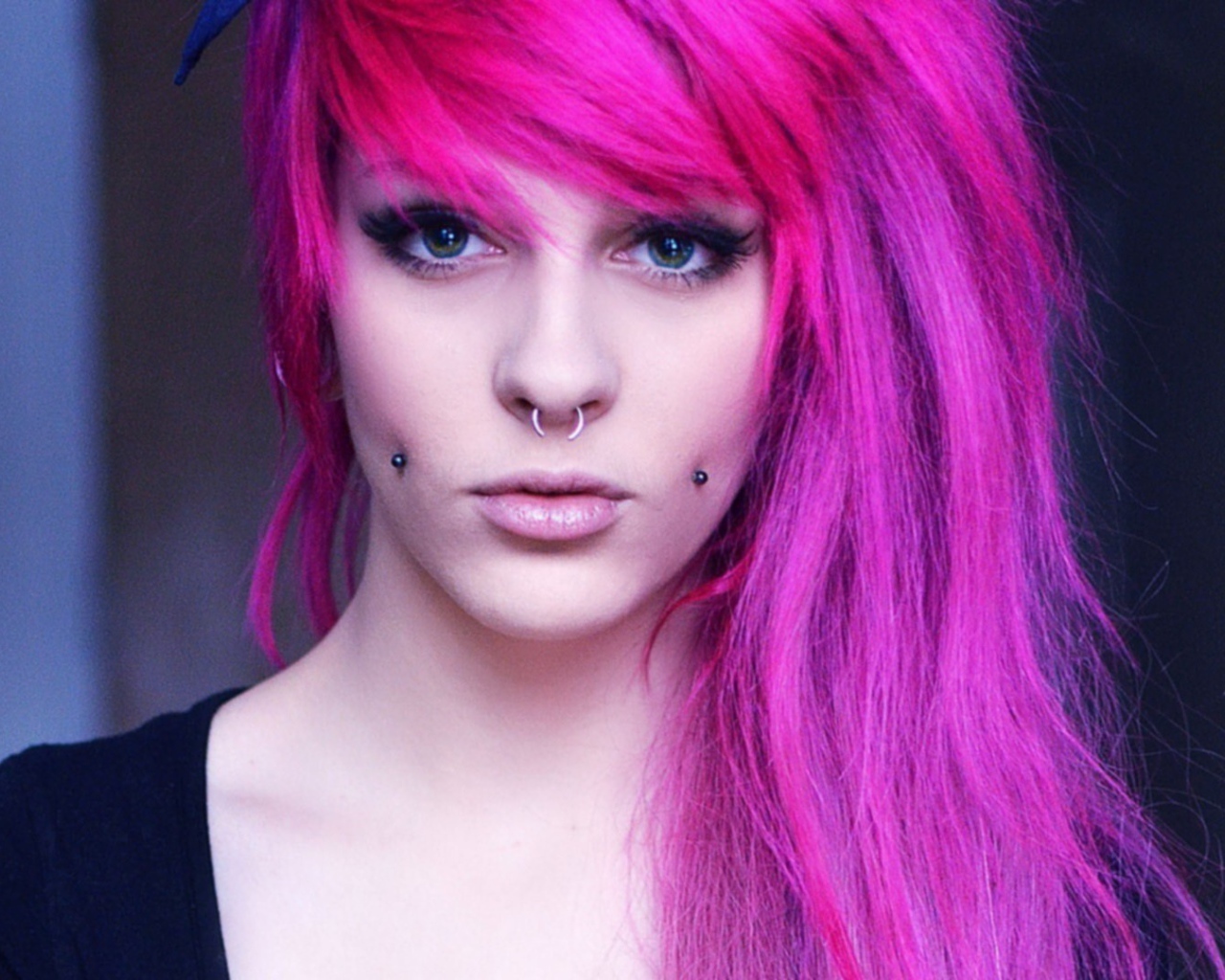 A girl with pink hair and piercings in her cheeks