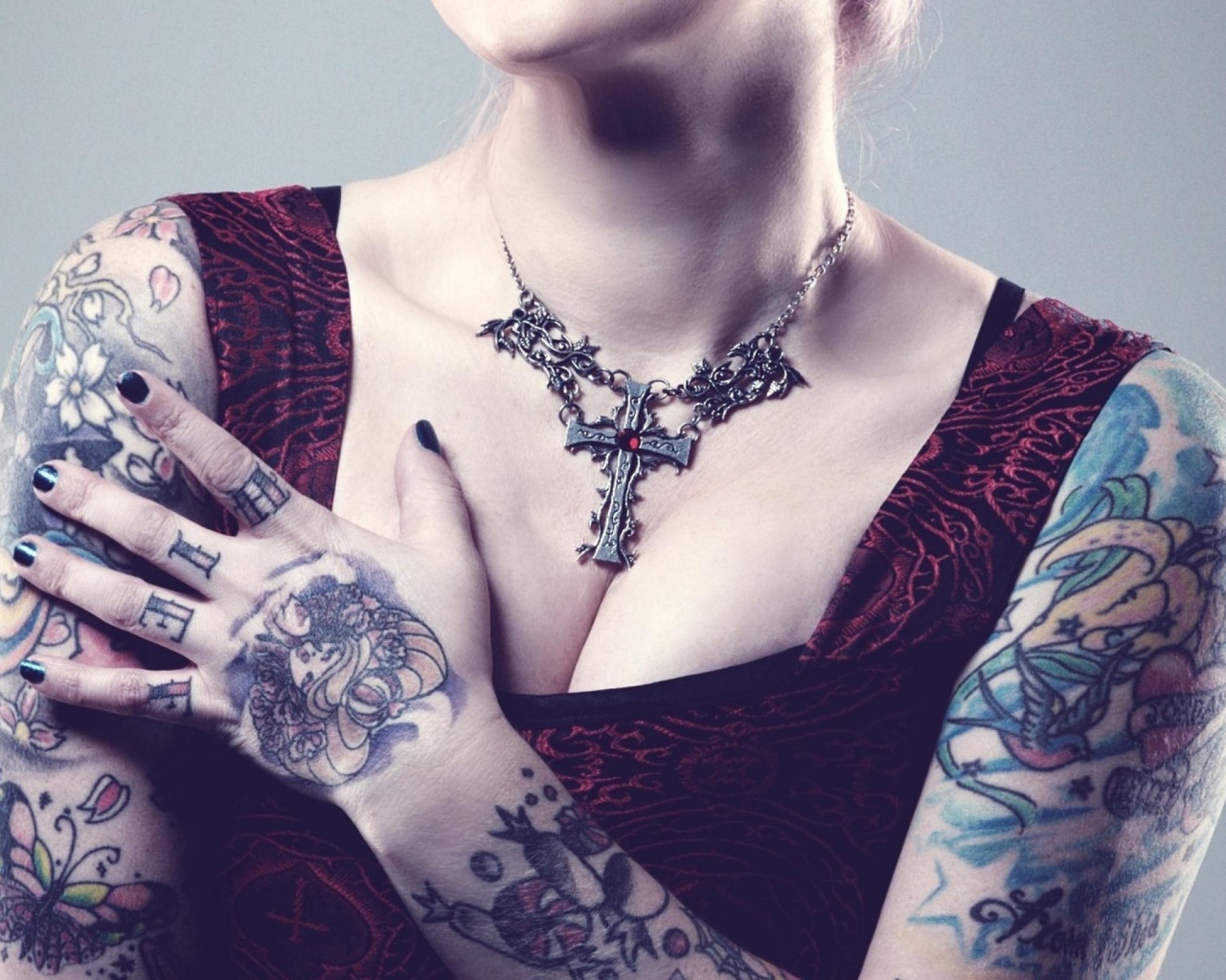 Красивый кулон на груди татуированной девушки