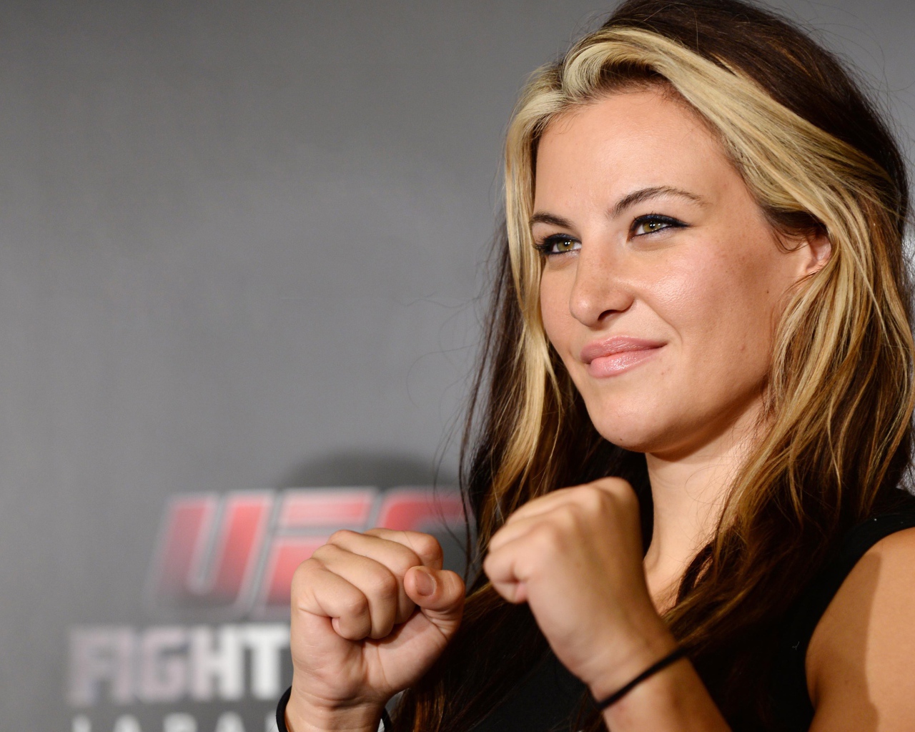 Блондинка Миша Тейт держит кулаки