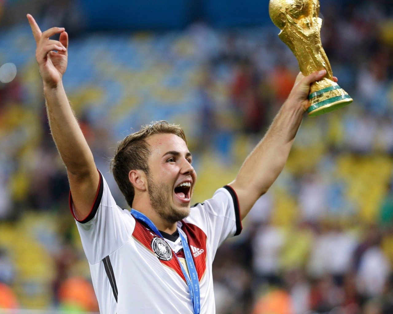 Немецкий футболист Марио Гётце держит в руке кубок
