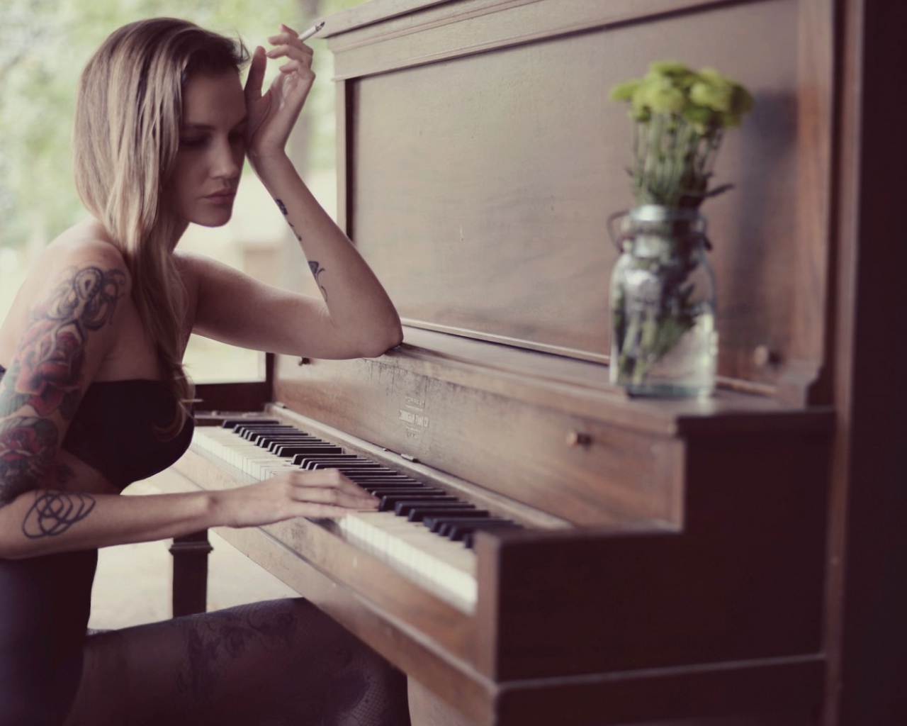 Девушка с тату играет на пианино