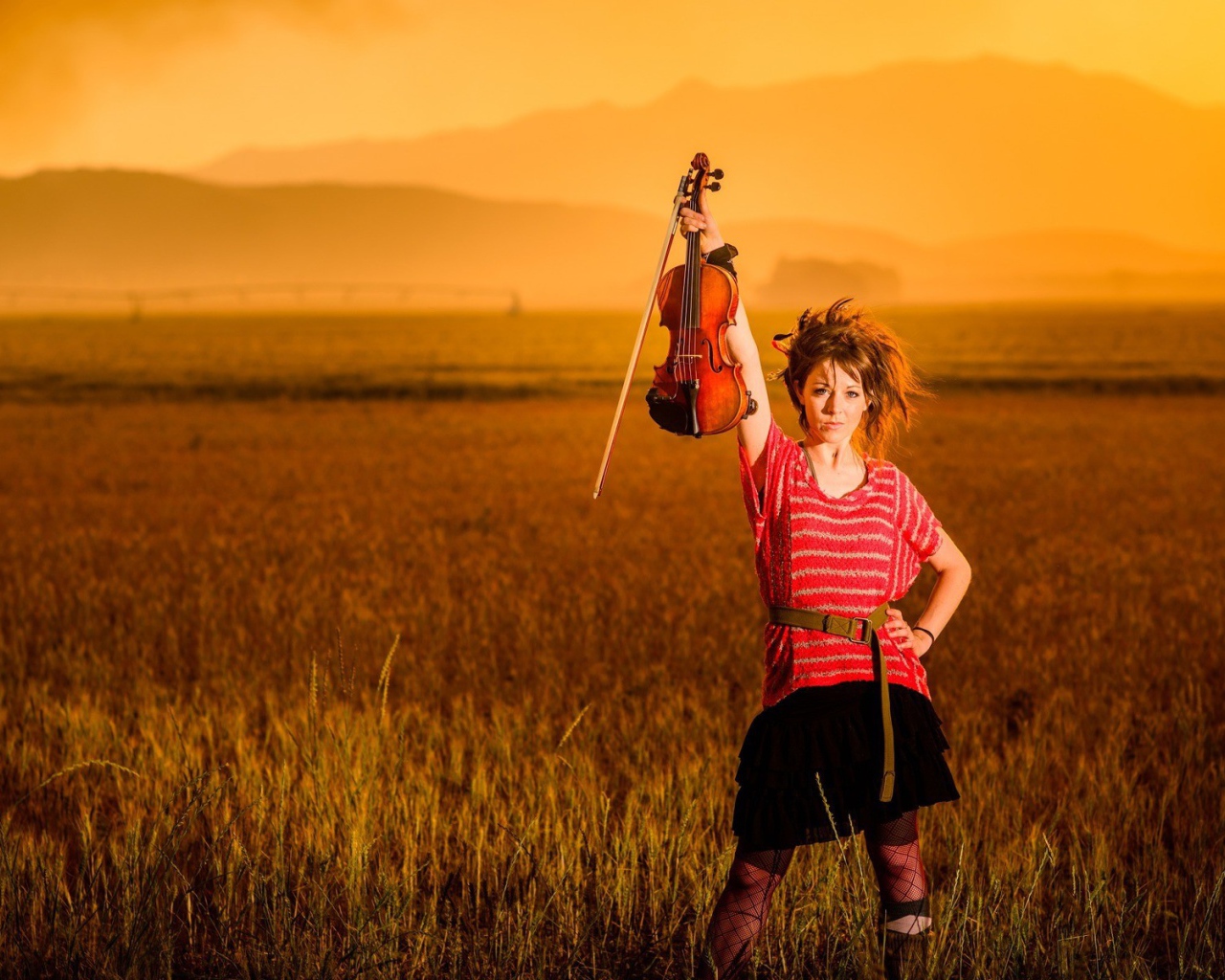 Скрипачка Линдси Стирллинг стоит в поле
