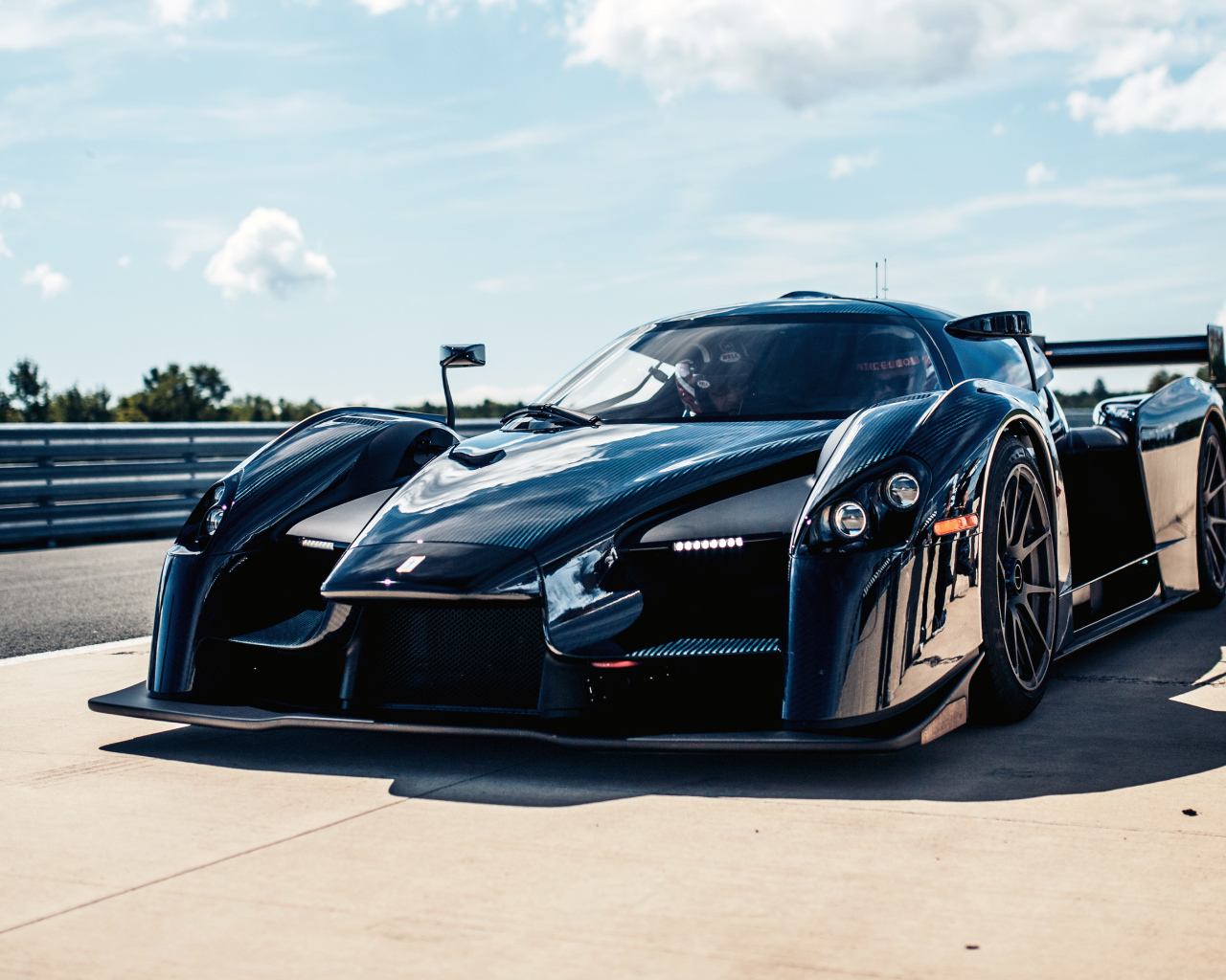 Черный быстрый спортивный автомобиль SCG 003CS на фоне голубого неба