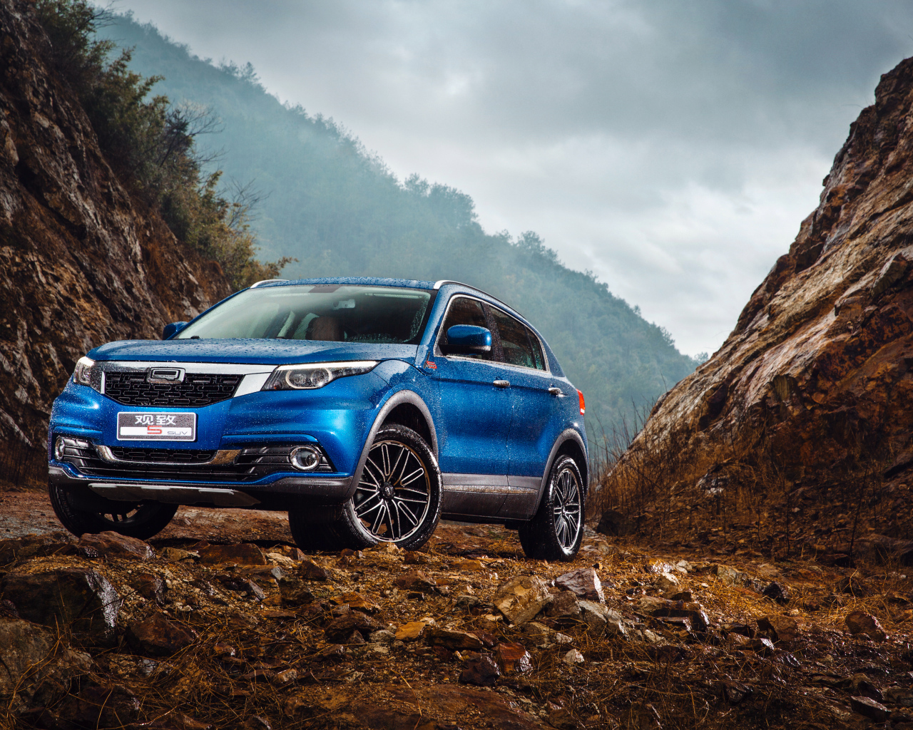 Синий китайский автомобиль Qoros 5  под дождем