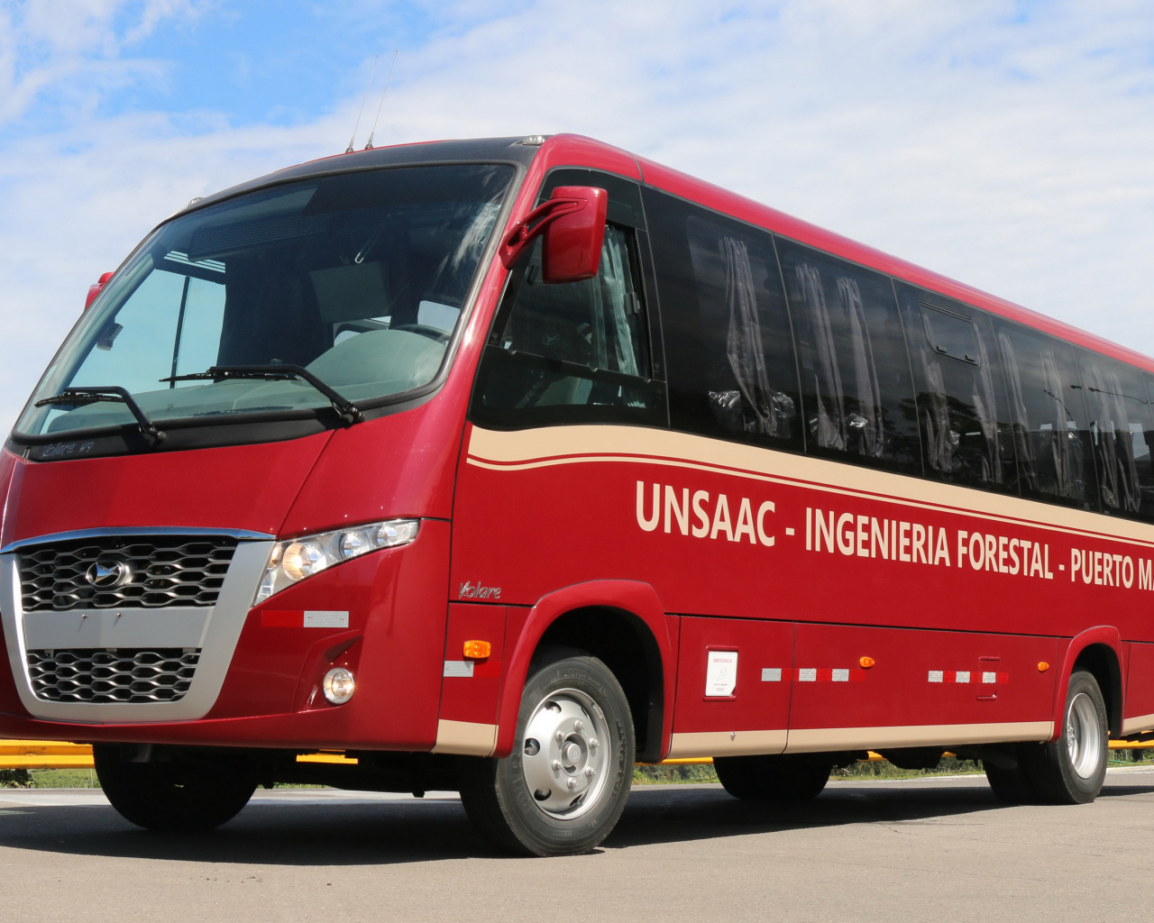 Красный автобус Volare W9 Executivo на дороге