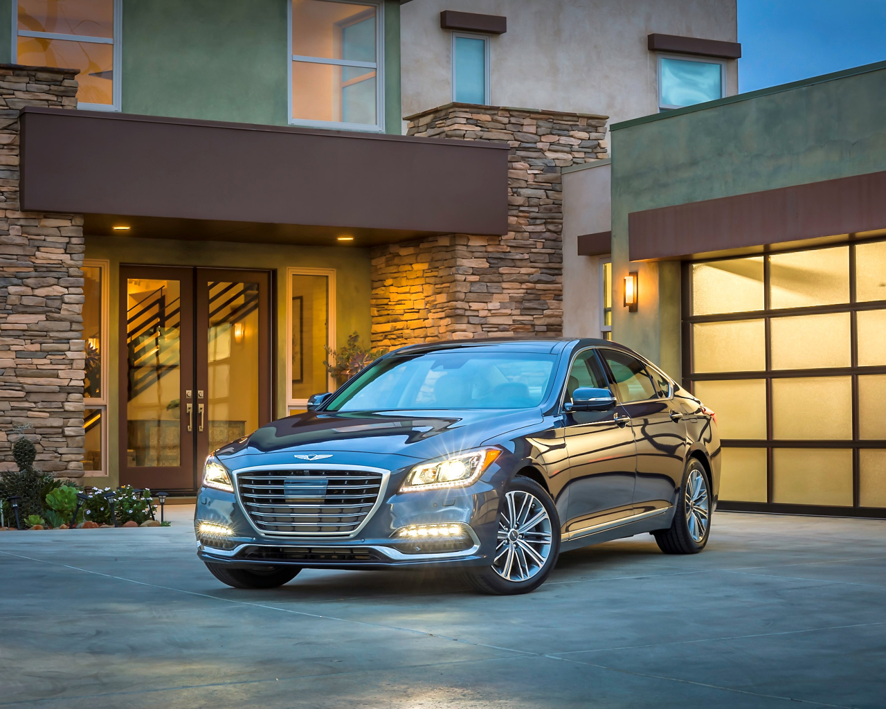 Серебристый автомобиль Genesis G80 с включенными фарами