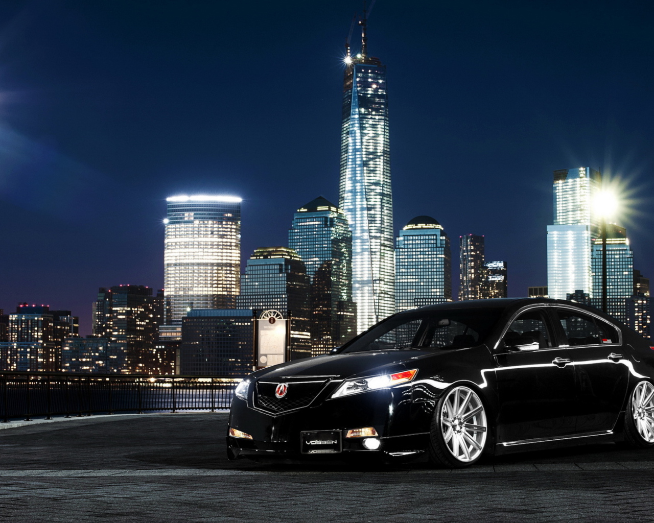 Черный автомобиль Acura TL на фоне ночных небоскребов 