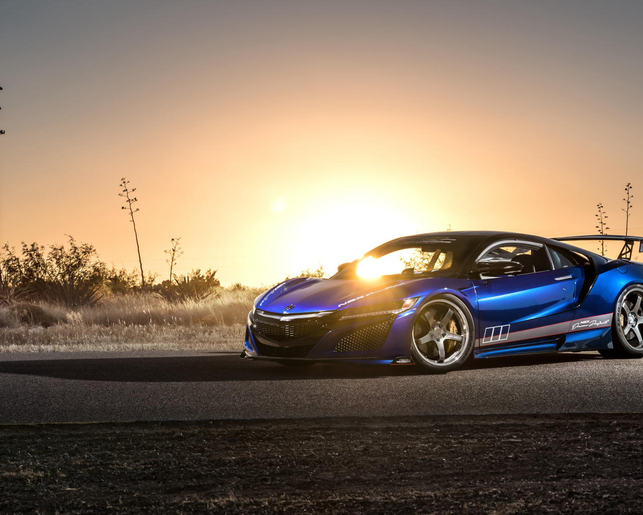 Синий спорткар Acura NSX, 2017 на фоне яркого солнца