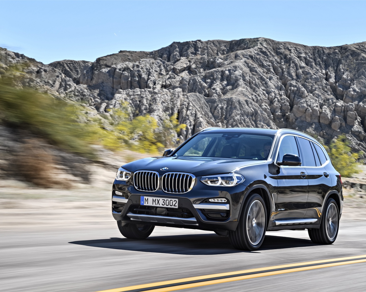 Черный красивый автомобиль BMW X3, 2018 на фоне гор