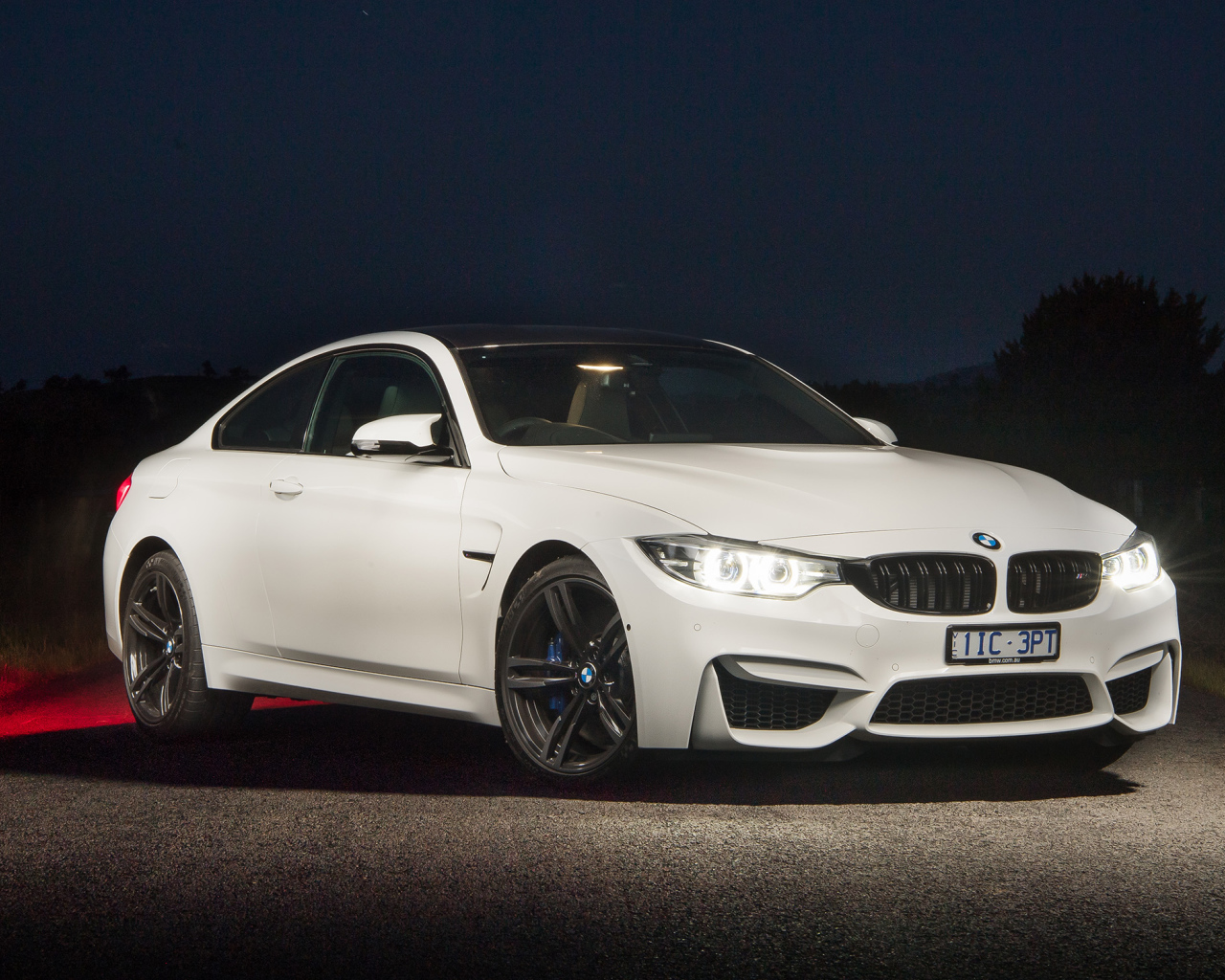 Белый автомобиль BMW M4 Coupe Pure Edition с включенными фарами