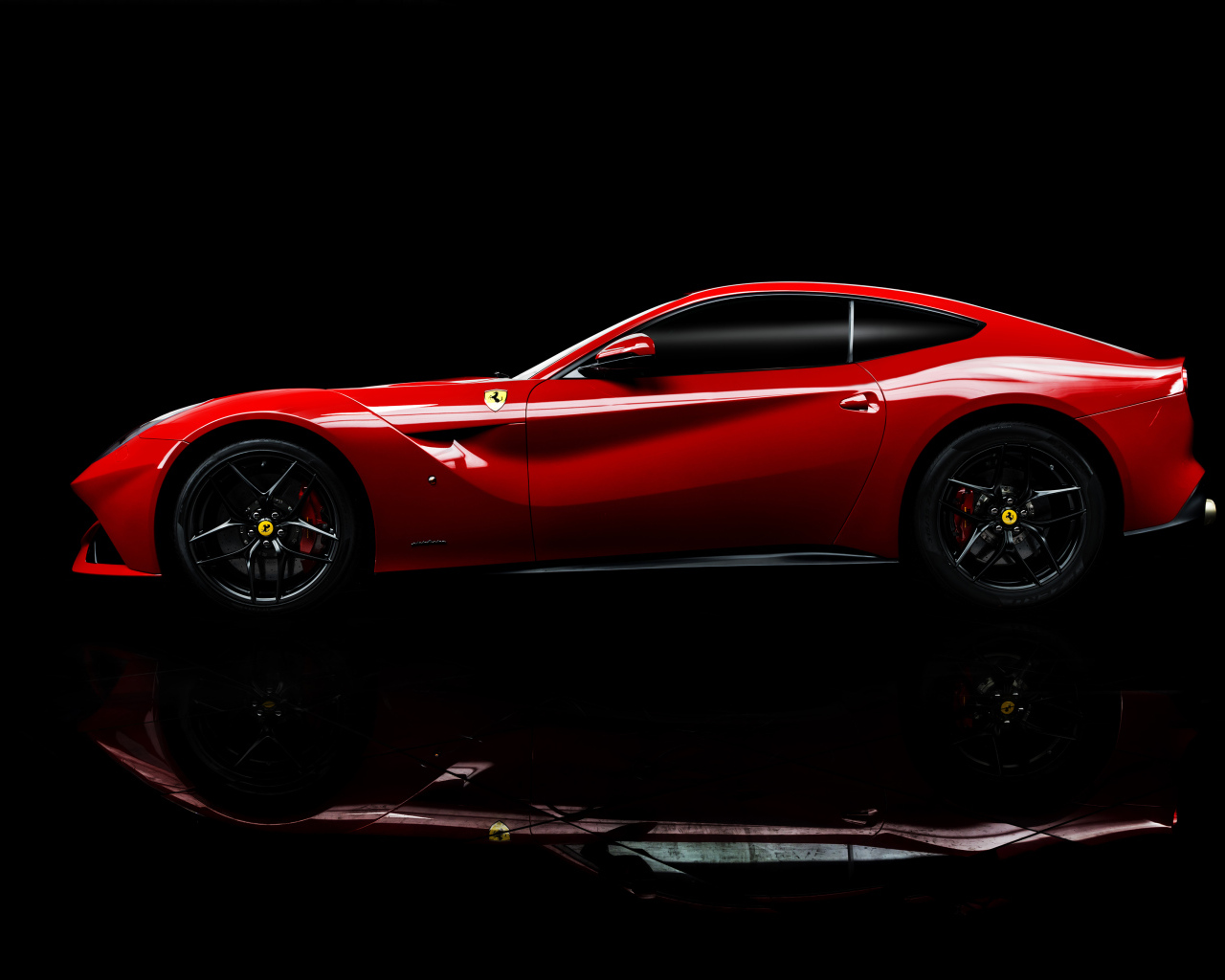 Красный спортивный автомобиль Ferrari F12 berlinetta на черном фоне