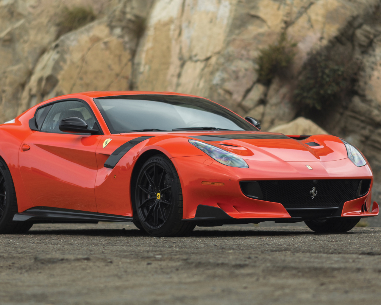 Красный спортивный автомобиль Ferrari F12tdf, 2017 у скалы
