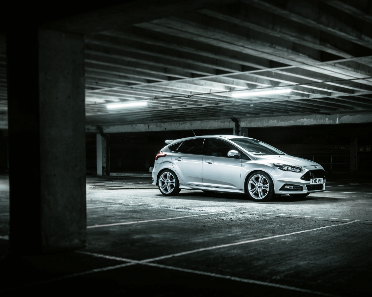 Серебристый автомобиль Ford Focus на подземной парковке