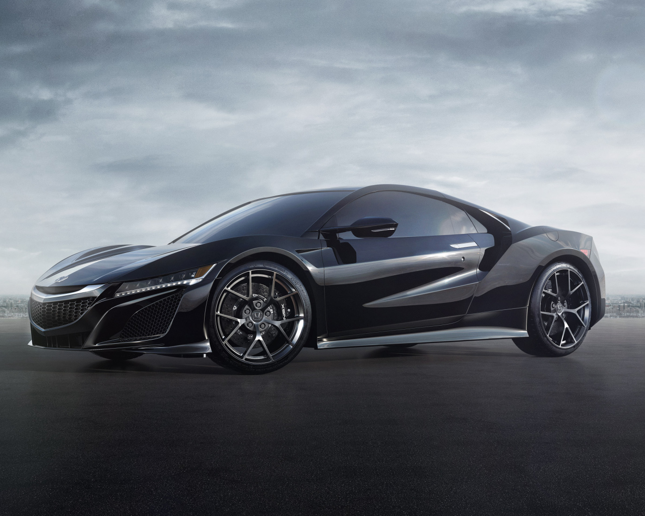 Черный спортивный автомобиль Honda NSX под пасмурным небом