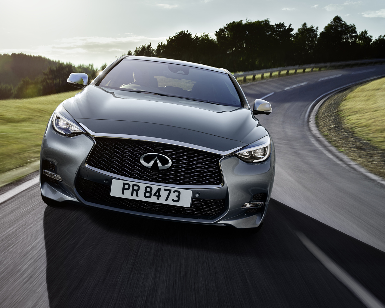 Серебристый автомобиль Infiniti Q30 на трассе