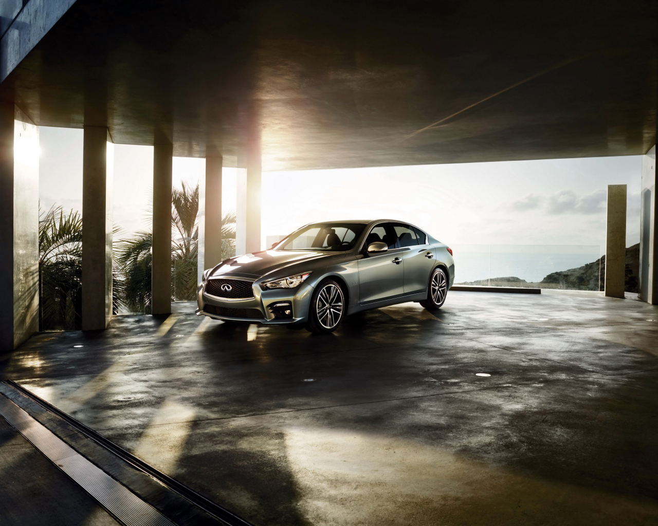 Серебристый автомобиль Infiniti Q50 в лучах солнца 