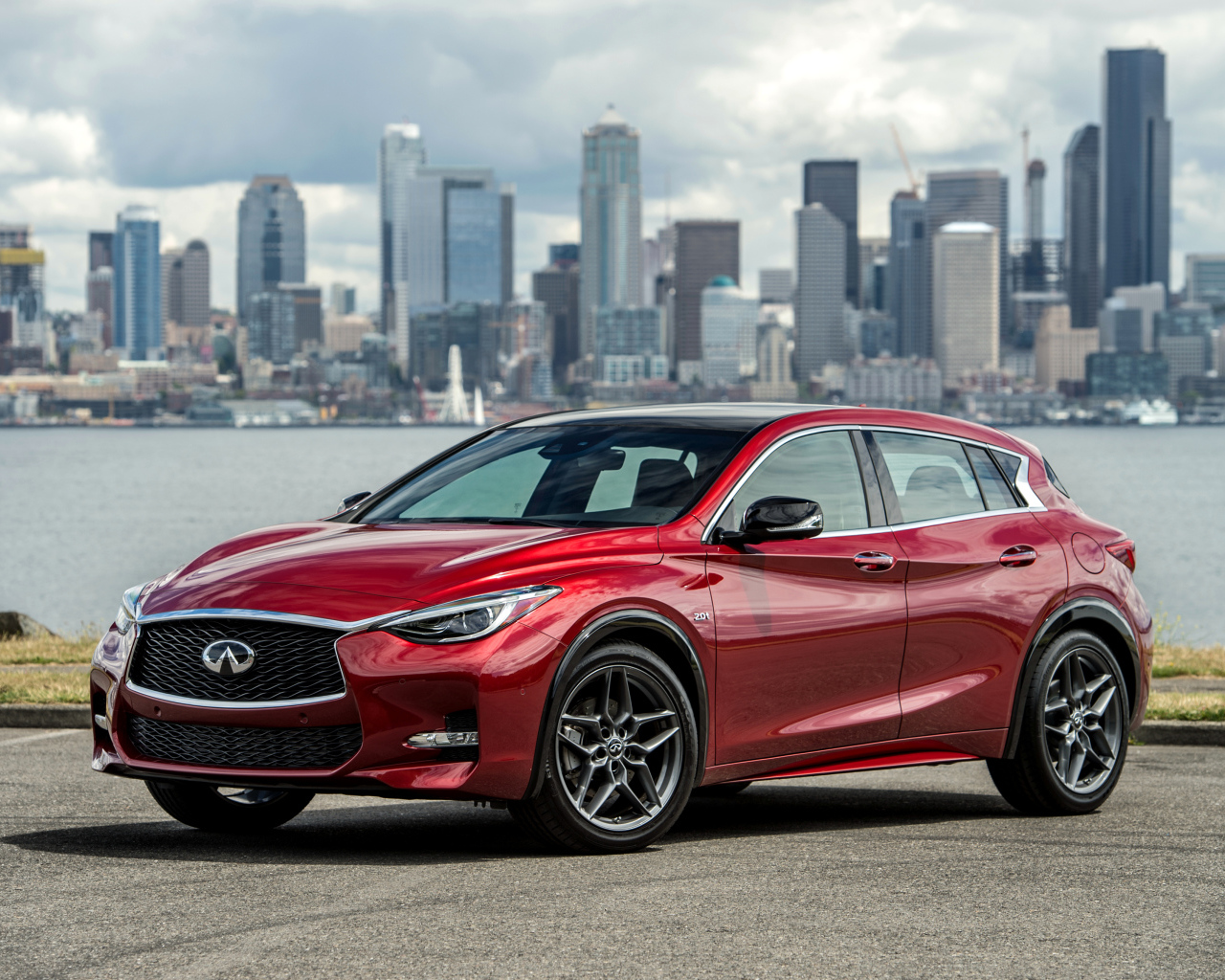 Бордовый автомобиль Infiniti QX30S 2.0t, 2017 на фоне города 