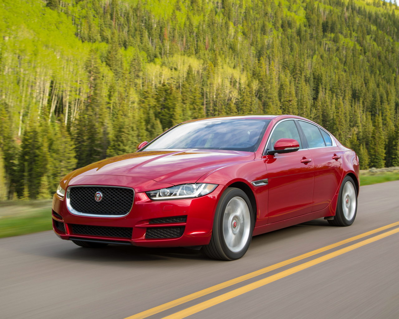 Автомобиль красного цвета Jaguar XE на трассе 