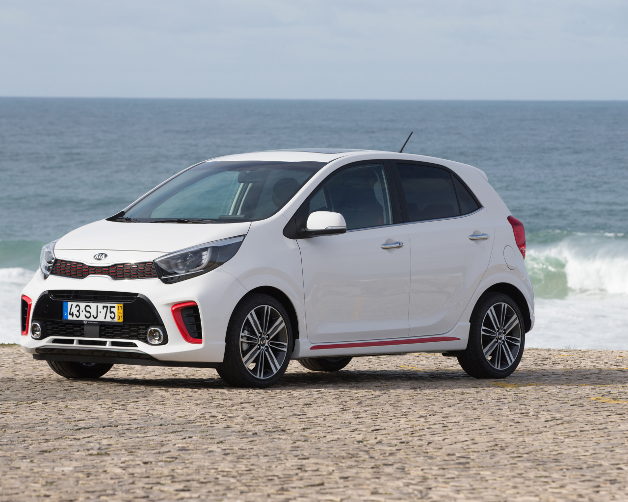 Белый автомобиль KIA Picanto GT Line, 2017 на фоне океана 