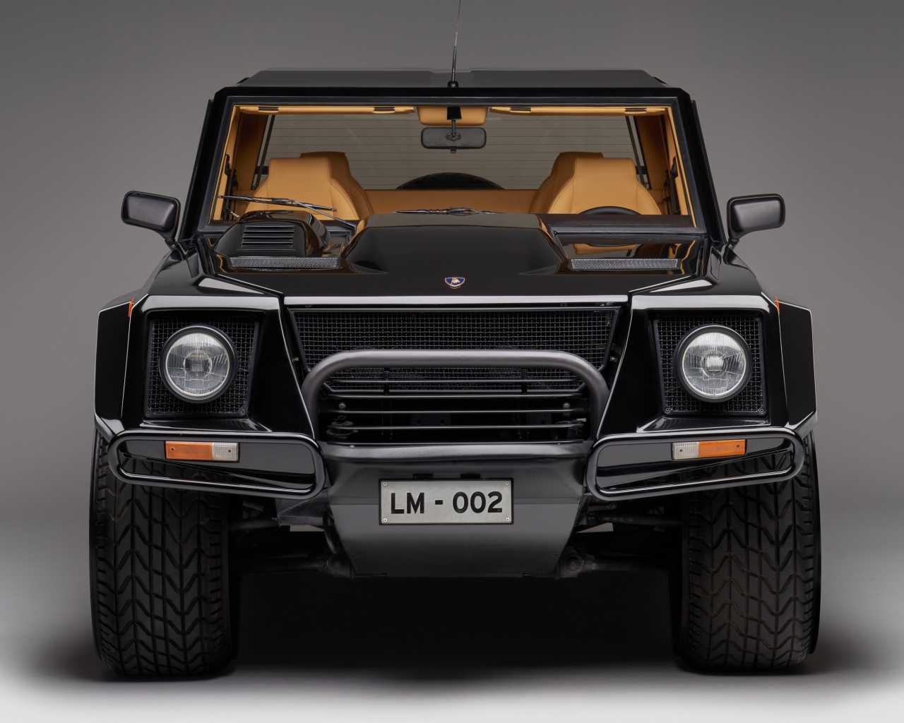 Черный автомобиль Lamborghini LM002 на сером фоне