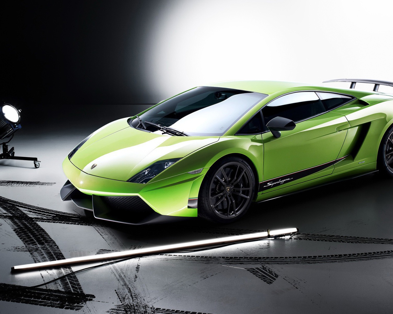 Спорткар Lamborghini Huracan салатового цвета в свете софитов 