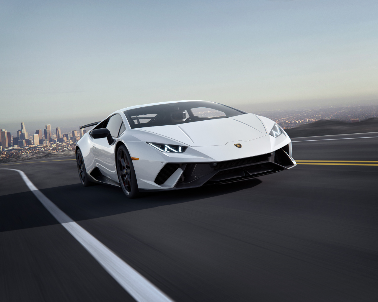 Белый спортивный автомобиль Lamborghini Huracan, 2018 на трассе