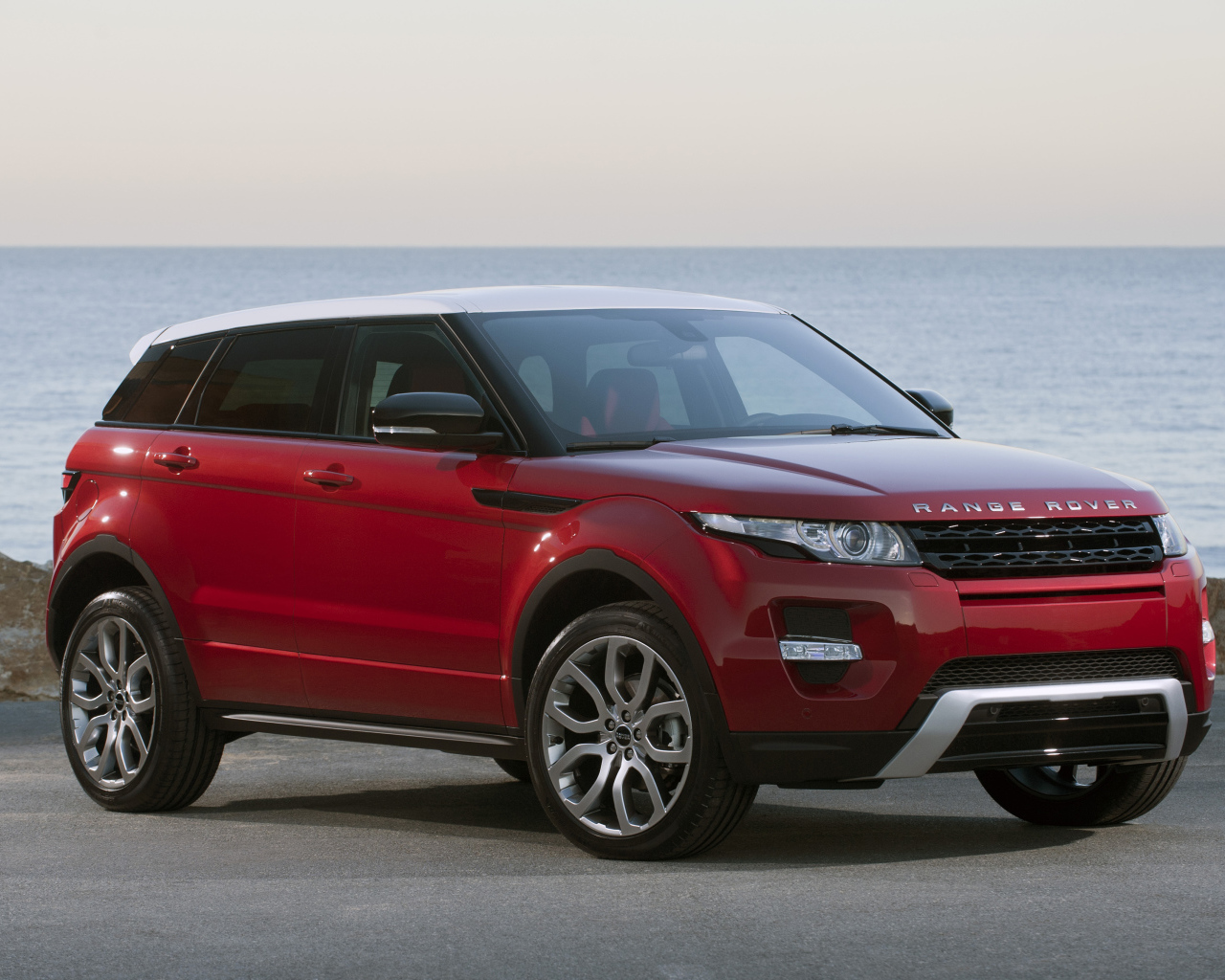 Красный автомобиль Land Rover Caractere на фоне океана