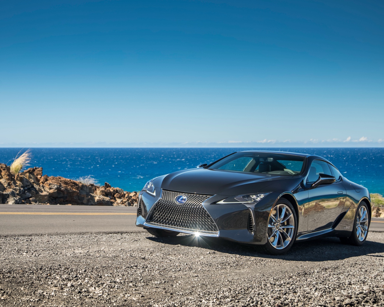 Блестящий серебристый Lexus LC 500 на фоне океана