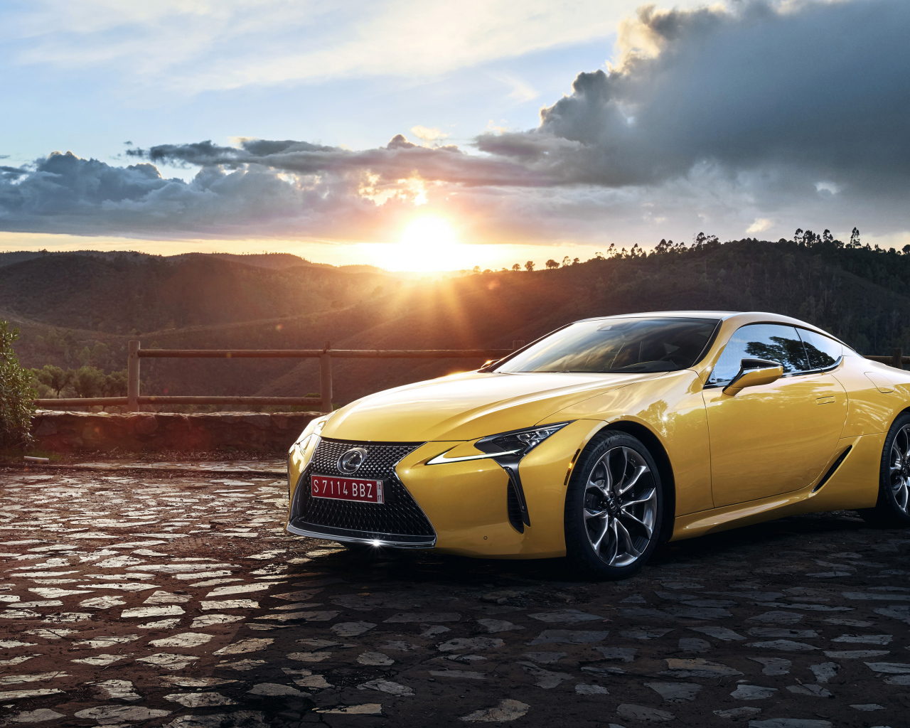 Желтый автомобиль Lexus LC 500  на фоне заката 