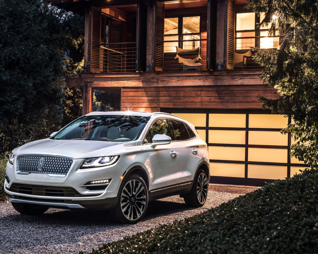 Серебристый автомобиль Lincoln MKC, 2019 у ворот гаража