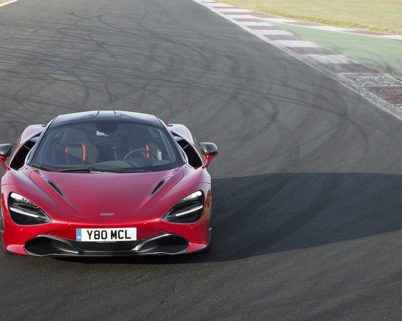 Красный гоночный автомобиль McLaren 720S на трассе 