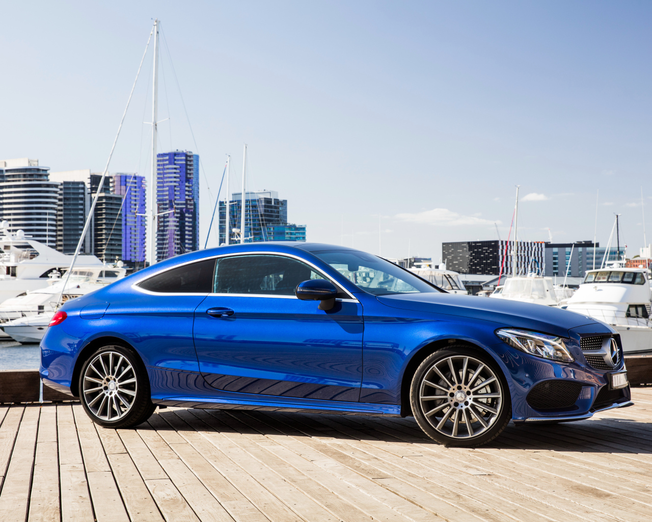 Синий автомобиль Mercedes-Benz C205 на фоне города