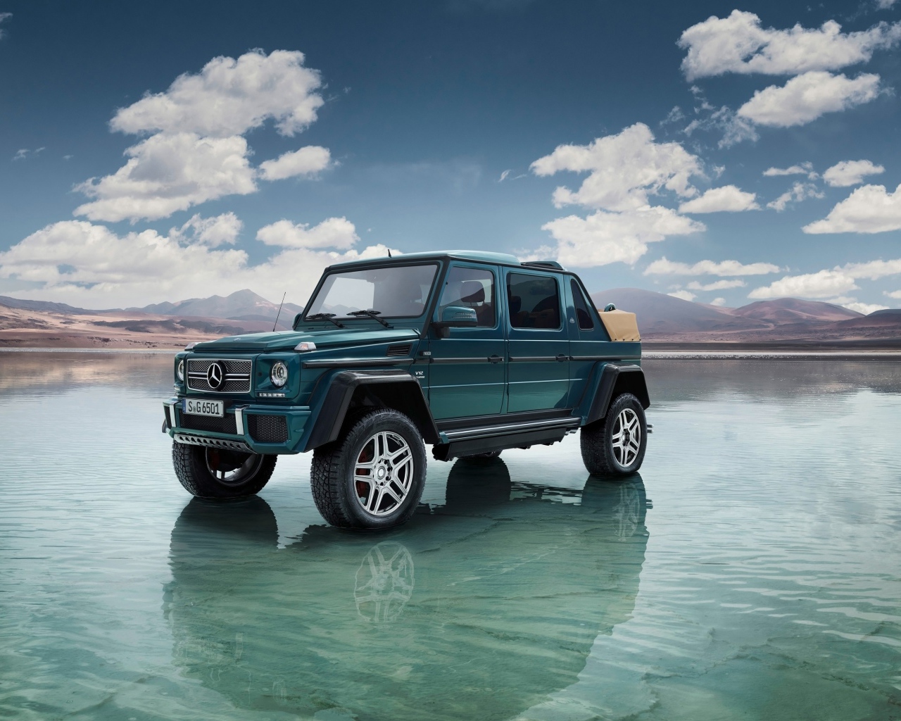 Зеленый автомобиль Mercedes-Maybach Landaulet G650, 2018 стоит в воде на фоне неба