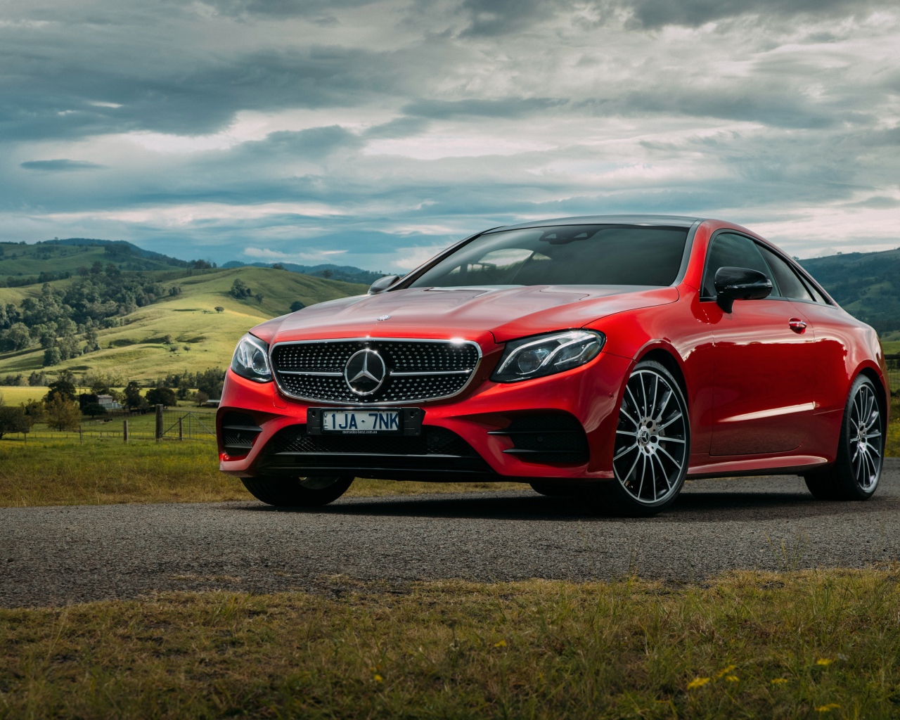 Красный автомобиль Mercedes-Benz E-Class на фоне природы