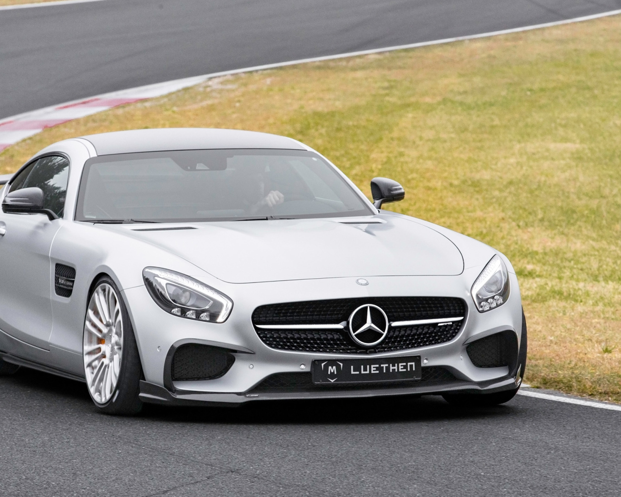 Серебристый автомобиль Mercedes-AMG GT на трассе