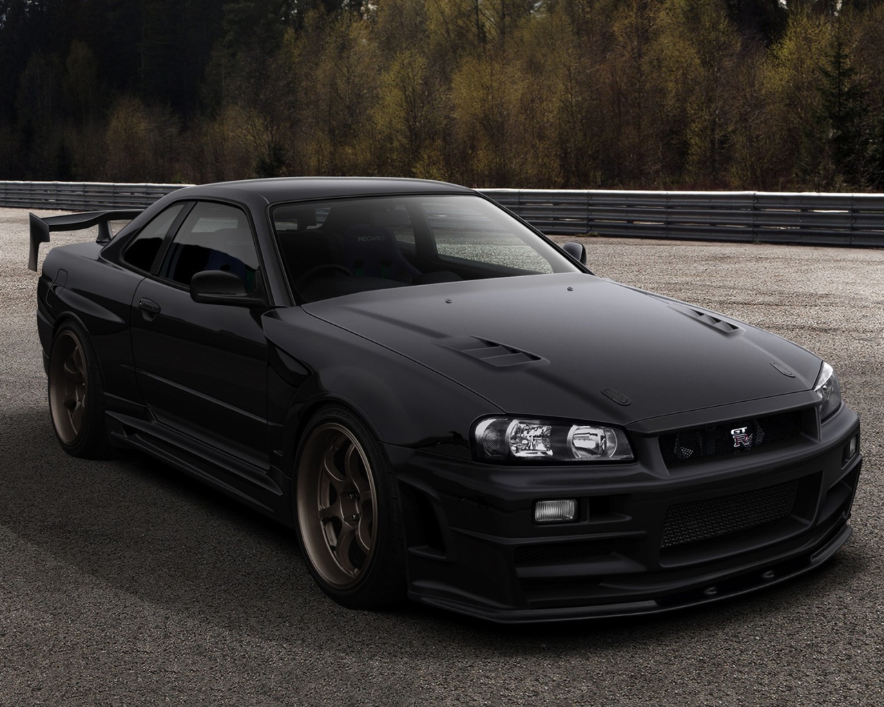 Черный автомобиль Nissan Skyline GT-R R34 на трассе
